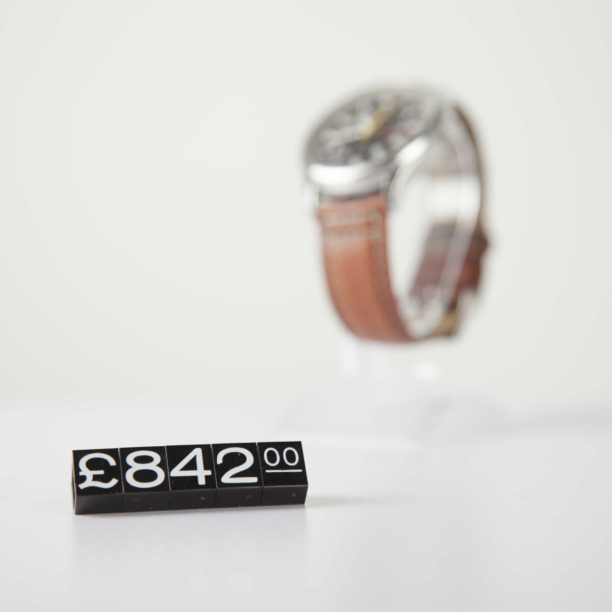 Retro black and white price tag cubes for retail displayed in front of a watch