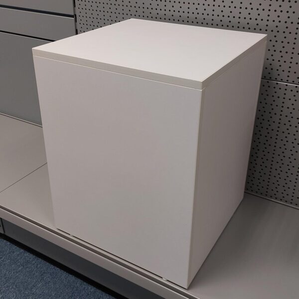 white mannequin plinth sitting on a grey metal shelf