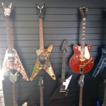 Black slatwall and inserts shown holding guitars in music shop